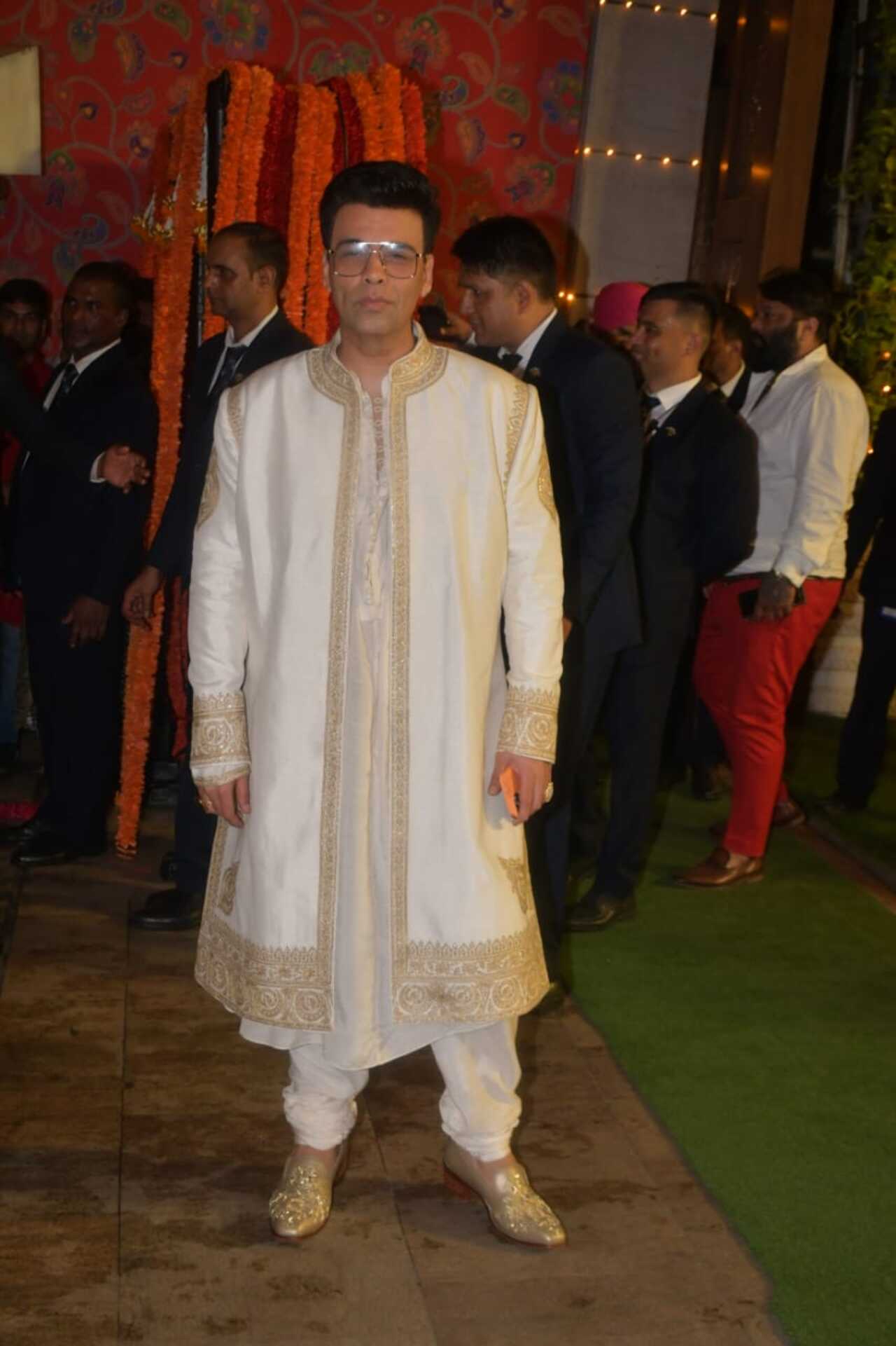 Karan Johar looked dapper in a white sherwani. He posed for the cameras happily